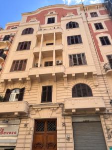 ein hohes weißes Gebäude mit Fenstern und Türen in der Unterkunft "Zigana" tra feste Siciliane - nel centro storico della città! in Palermo