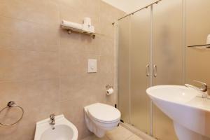 un bagno con WC, lavandino e doccia di Hotel Numi a Rimini Altre 42 foto