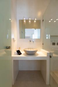 a bathroom with a bowl sink and a mirror at Cycladic Suites in Naousa