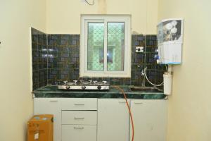 a kitchen with a sink and a window at Puri studio apartment in Puri