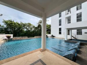 a swimming pool next to a white building at Oceanview Condo in Boracay in Boracay