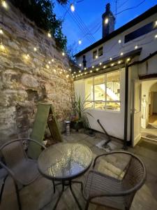 a patio with a table and chairs and lights at Carrow Cottage in Ironbridge