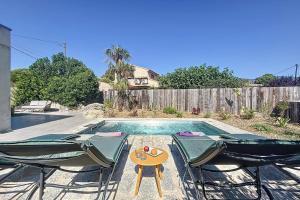 una piscina con 2 sillas de césped y una mesa en Contemporary villa with pool in Trinité, en Porto Vecchio