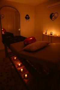a bedroom with a bed with candles and a mirror at Love Room Royan in Royan