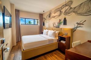 a hotel room with a bed and a desk at The Henry Hotel Roost Bacolod in Bacolod