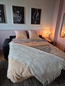 a bed in a bedroom with two pictures on the wall at Loveroom Eclat d emoi in Condé-sur-Noireau