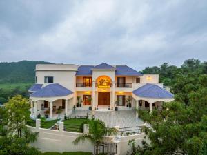 a large white house with blue roofs at Villa Sol- A Hilltop Villa in Udaipur in Jāmb