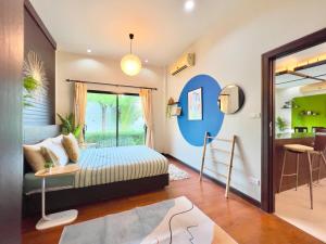 a bedroom with a bed and a living room at MYSA House Pool Villa Central Phuket in Phuket