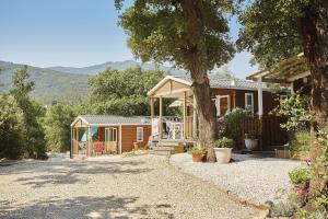 Camping des Alberes في Laroque-des-Albères: بيت فيه شرفه وشجر