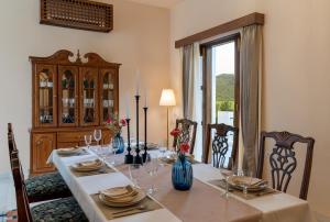 a dining room with a table with chairs and a large window at Villa Sol- A Hilltop Villa in Udaipur in Jāmb