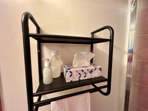 a black shelf with a bottle and a box of tissues at Le Chat De Lamartine - Clim Parking in Saint-Pierre-dʼAlbigny +17 photos