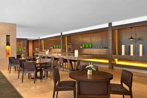 a restaurant with tables and chairs and a bar at The Westin Mumbai Garden City in Mumbai