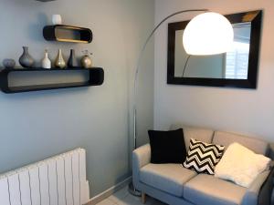 a living room with a couch and a lamp at Studio calme et confort avec Wifi et terrasse proche de CNPE Cruas in Montélimar