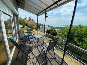un portico con sedie e un tavolo sul balcone di Ravenswood Cottage a Balatonfůzfő