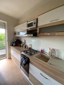 una cucina con lavello e fornello forno superiore di Ravenswood Cottage a Balatonfůzfő