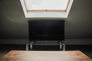 スウォンジーにあるCity Centre 6-Bed Swansea Getawayの窓の下のテーブルに置かれた薄型テレビ