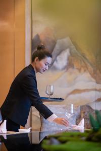 a woman standing in front of a table with wine glasses at Hilton Wuhan Yangtze Riverside in Wuhan +81 photos