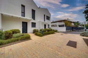 a white house with a brick driveway at La Villa Caudéran - Déco chic et bohème in Bordeaux