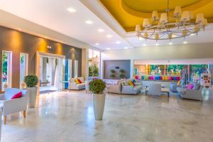 a lobby with couches and chairs and a chandelier at Kipriotis Hippocrates Hotel in Kos