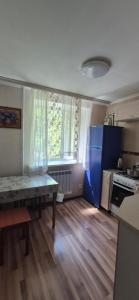 a kitchen with a table in the middle of a room at 1 комнатная квартира in Turksib