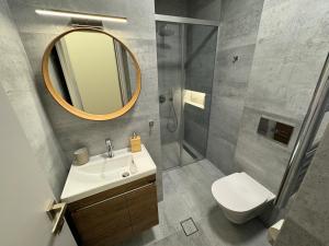 a bathroom with a sink and a shower and a mirror at Flat With Incredible Sea View in Patra +19 photos
