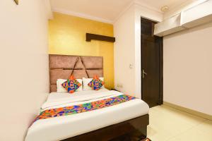 a bedroom with a large bed with colorful pillows at FabHotel Delhi Continental in New Delhi +24 photos