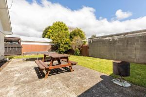 a picnic table and a bench in a backyard at Home away from home 4 bedroom 2 bathrooms in Upper Hutt