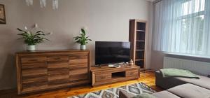 a living room with a television on a wooden dresser at Apartament 2 pokojowy z widokiem na morze in Sarbinowo