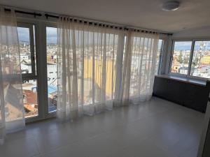 a large room with large windows with white curtains at Horizon d'Ankadifotsy in Antananarivo