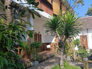 a courtyard of a house with trees and plants at Dili Gili in Gili Trawangan