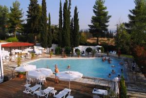 a large swimming pool with people sitting around it at To NEON in Loutra Ipatis