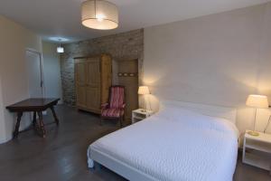 a bedroom with a bed and a table and a chair at Le Faing Du Bray in Plombières-les-Bains