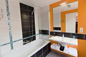 a bathroom with a tub and a sink and a mirror at Le Faing Du Bray in Plombières-les-Bains +27 photos