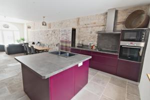 a kitchen with purple cabinets and a counter top at Le Faing Du Bray in Plombières-les-Bains