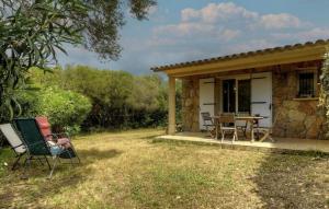 a cottage with a table and chairs in the yard at Les bergeries d'Ogliastrello in Figari