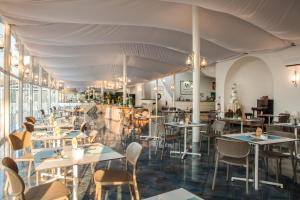 a restaurant with tables and chairs in a room at Hotel New Barcavela in Santa Margherita di Pula