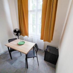 a table and chairs in a room with a window at Friends on the Road D4 Prague in Prague