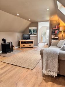 a living room with a couch and a tv at Natures Loft in Darlington