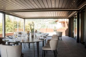 a dining room with tables and chairs and a large window at Borgo Capietaglio Wine Resort in Gromlongo
