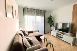 a living room with a couch and a flat screen tv at Ático de proa, en la mejor playa del Médano in Granadilla de Abona