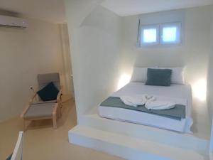 a bedroom with a bed with two towels on it at Κτήμα Ανάσες Ζωής- Ευγενία Σγούρα in Epanomi
