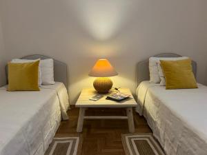 a room with two beds and a table with a lamp at Villa Luisa Guest House in Scanzano