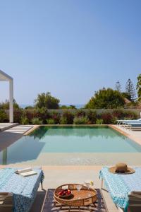 a pool with two chairs and a table with fruit on it at Villa Mareiva - Heated Pool, Beach 150 mt in Pozzallo