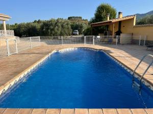 a swimming pool with blue water in a yard at Aldora Rural Casa con piscina in Moratalla