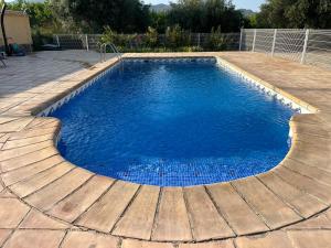 a swimming pool with blue water in a yard at Aldora Rural Casa con piscina in Moratalla +34 photos