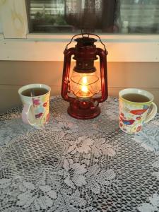 a lantern sitting on a table with two cups at Valeria kamping in Uusküla