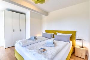 ein Schlafzimmer mit einem großen Bett mit blauen Kissen darauf in der Unterkunft Ferienwohnung Strandloft 12 im Haus Düne 7 Prora in Binz