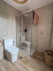 a bathroom with a toilet and a glass shower at Apartamento en Somo in Somo