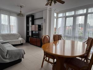 a living room with a table and a couch at Centro y playa, tu apartamento ideal en SOMO con Parking in Somo