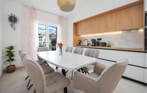 a dining room with a white table and chairs at Nice Home In Rogotin With Harbor View in Rogotin